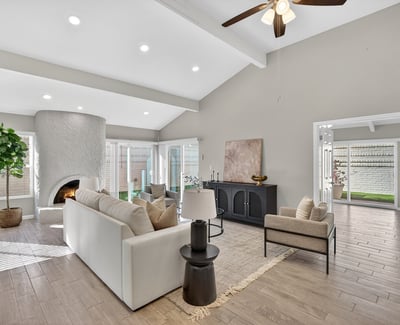 Inviting living room with vaulted ceilings, architectural fireplace, and sliding glass doors opening to private outdoor areas.