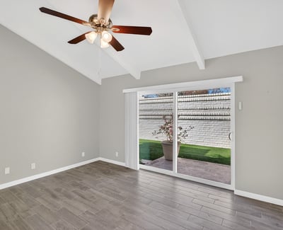 Bedroom featuring sliding glass doors to the courtyard, vaulted ceiling, and bright natural light enhancing the living experience.