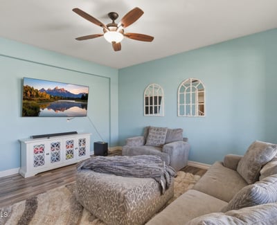 Front living room featuring soft natural light, updated flooring, and comfortable seating space perfect for relaxing or welcoming guests.