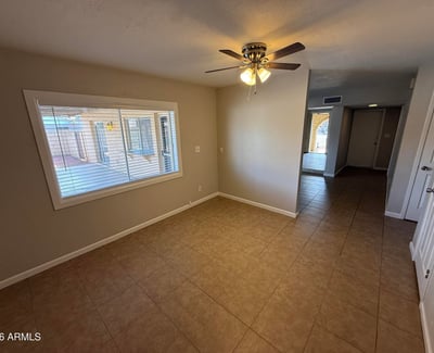 Bedroom with sliding doors opening directly to the backyard patio and pool area. Natural light and tile flooring enhance the bright feel of the room.