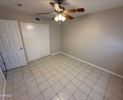 Bright bedroom with tile flooring and ceiling fan light fixture. The simple layout provides flexibility for furniture arrangement and everyday comfort.