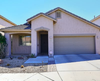 Full front view with covered entry, stucco exterior, and attached garage. This Phoenix home delivers style and functionality.