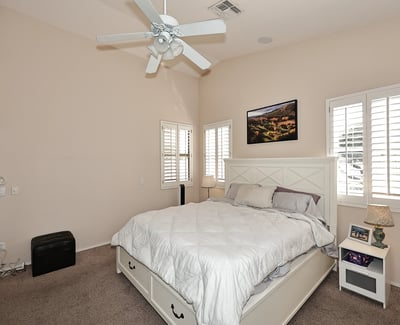 Comfortable primary suite with large windows, soft carpet, and open layout. This Phoenix home provides a relaxing retreat with functional space and natural light.