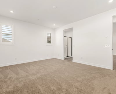 Generous primary suite with soft carpet, large windows, and peaceful ambiance. Designed for comfort and privacy.