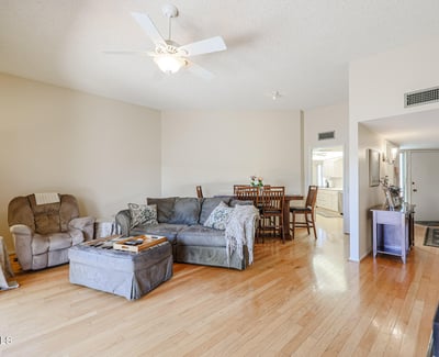 Open living and dining area with hardwood flooring, ceiling fan, and easy flow into the kitchen, ideal for gatherings and daily living.