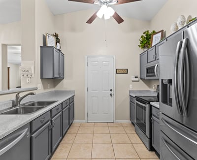 Stylish kitchen showcasing stainless steel appliances, generous cabinet storage, and functional layout open to main living areas.