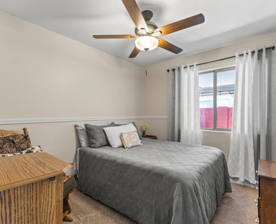 Cozy bedroom with carpet flooring, ceiling fan, and functional layout for everyday living.