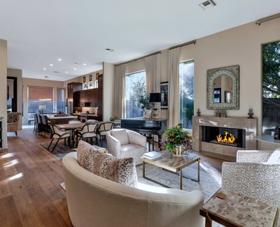 Spacious living area with high ceilings, wood floors, and a modern fireplace creating a warm and inviting atmosphere in this Phoenix home designed for entertaining.