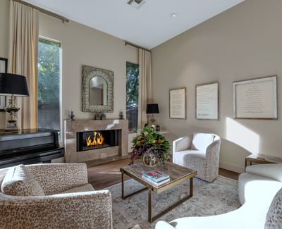 Sun-filled living room featuring designer d cor, a sleek fireplace, and large windows that enhance the open feel of this Phoenix home.