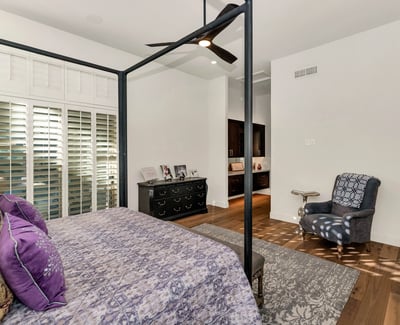 Inviting bedroom with ceiling fan, plantation shutters, and warm finishes, perfect for guests or additional living space in Phoenix.
