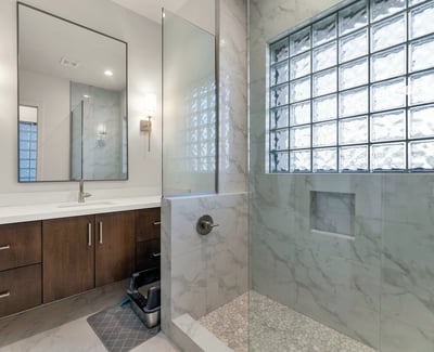 Well-appointed bathroom with dual sinks, updated cabinetry, and glass block accents for natural light in this Phoenix home.