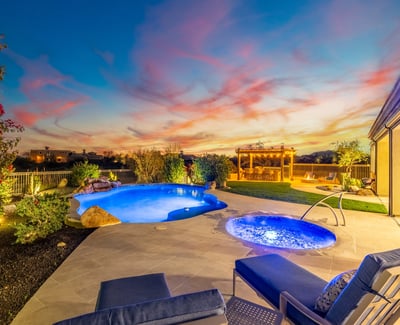 Stunning backyard oasis with pool, spa, pergola, and desert landscaping, showcasing Scottsdale luxury outdoor living during golden hour.