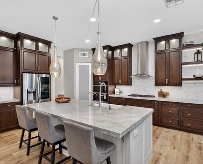High-end kitchen with quartz island, farmhouse sink, custom cabinetry, and stainless steel appliances in this Scottsdale home.