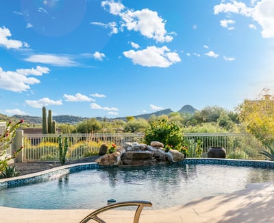 Scottsdale backyard pool overlooking scenic desert and mountain views, enhanced by mature landscaping and peaceful surroundings.