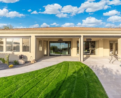 Scottsdale outdoor space with covered patio, green lawn, and sliding glass doors, creating seamless indoor-outdoor living.
