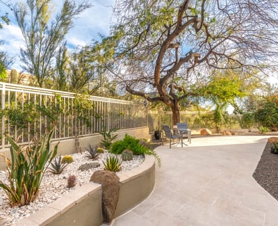 Scottsdale side yard with low-maintenance desert landscaping, stone accents, and paved walkway for easy upkeep.