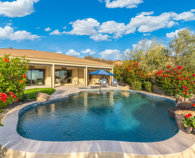 Scottsdale outdoor space featuring pool, spa, and lush landscaping, creating a resort-style backyard retreat.