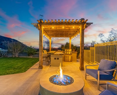 Scottsdale patio with fire pit, pergola, and outdoor kitchen area, offering a cozy and stylish entertaining space.
