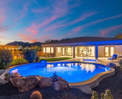 Scottsdale outdoor space with pool, spa, and landscaped yard, creating a serene and inviting nighttime retreat.
