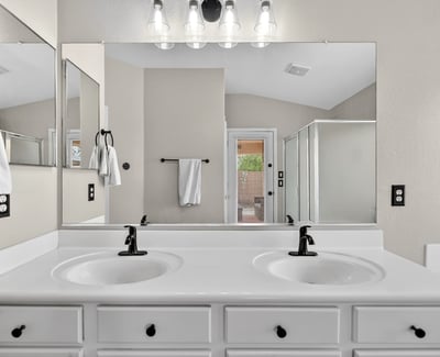 Spacious primary bathroom with dual vanities and modern fixtures. Functional layout enhances everyday convenience in Casa Grande.