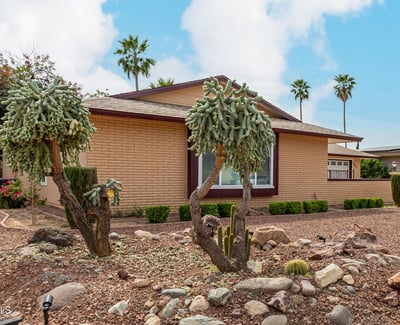 Unique desert garden with mature cacti and rock accents. This Sun City home offers beautiful curb appeal with water-efficient landscaping.