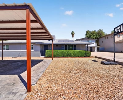 Clean front yard with gravel landscaping and covered parking, designed for durability and ease in this Phoenix multi-unit home.
