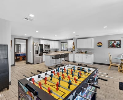 Versatile space combining game area and kitchen access, ideal for entertaining and flexible living arrangements.