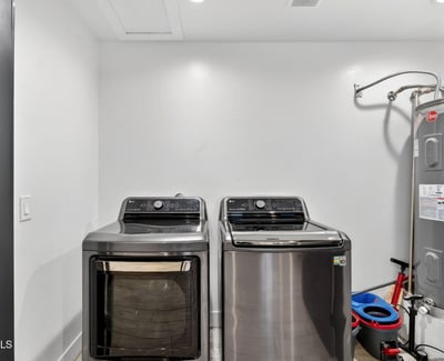 Functional laundry area with washer, dryer, and water heater, designed for efficiency and convenience in this Phoenix home.