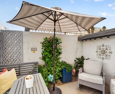 Relax in a private Scottsdale patio featuring shaded seating, decorative accents, and low-maintenance landscaping ideal for outdoor living and entertaining.