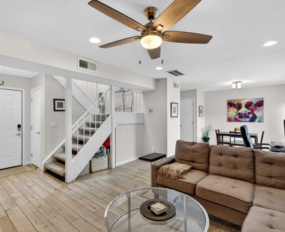 Spacious Scottsdale living area with tile flooring, ceiling fan, and open flow to dining and patio, perfect for comfortable everyday living.