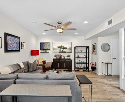 Inviting Scottsdale living space with staircase feature, updated flooring, and open flow connecting living, dining, and kitchen areas.