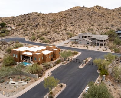 Secure gated entrance welcomes residents into an upscale hillside neighborhood surrounded by luxury custom homes and scenic desert landscapes near South Mountain Preserve.