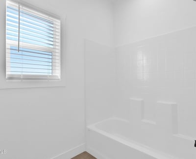Bright full bathroom featuring a tub and shower combination, contemporary fixtures, and crisp finishes. Natural light and thoughtful design create a comfortable and welcoming space for residents and visitors.