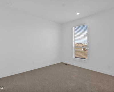 Comfortable bedroom with soft carpeting, neutral d cor, and a large picture window. This flexible room is ideal for guests, family members, or a dedicated office setup.