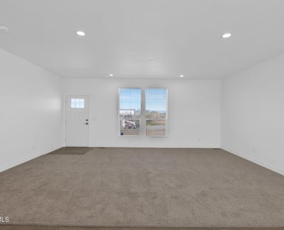 Bright front living area featuring large windows, open sightlines, and comfortable finishes. This flexible space provides plenty of room for entertaining, relaxing, or creating a customized living environment in Wittmann.
