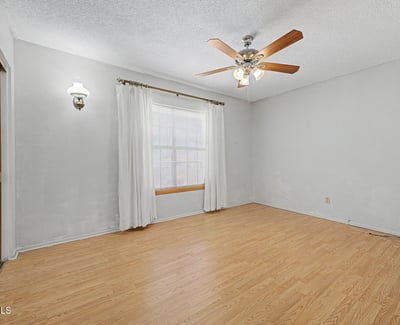 This bright secondary bedroom offers natural light, a ceiling fan, and attractive flooring. Its versatile layout makes it ideal for guests, family, remote work, or creative hobbies.