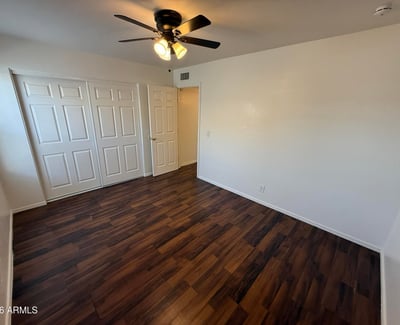 Well-appointed bedroom with ceiling fan, ample closet storage, and attractive flooring throughout. This comfortable space offers privacy and flexibility for residents seeking functional living areas.