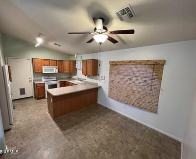 Functional kitchen featuring extensive cabinetry, a breakfast bar peninsula, and adjacent dining space. The thoughtful design allows easy interaction with guests while preparing meals.