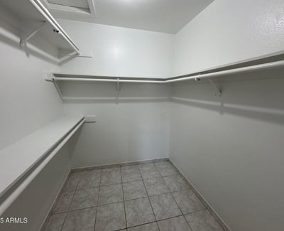 Generously sized walk-in closet featuring extensive hanging space, shelving, and room for organized storage. Ideal for keeping wardrobes and personal items neatly arranged.