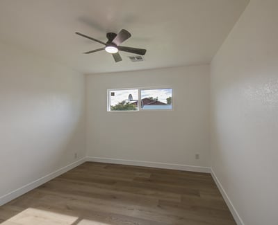 This welcoming bedroom features modern flooring, fresh interior finishes, ceiling fan, and versatile space suitable for guests, children, or a home office.
