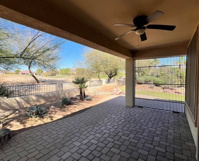 Covered patio featuring paver flooring, ceiling fan, screened enclosure, and peaceful views overlooking the golf course and professionally landscaped backyard. An ideal extension of the home's indoor living space.