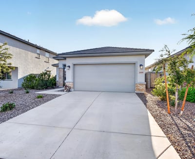 Charming front exterior showcases modern architecture, stone accents, desert landscaping, and a spacious attached garage, delivering outstanding curb appeal in Surprise.