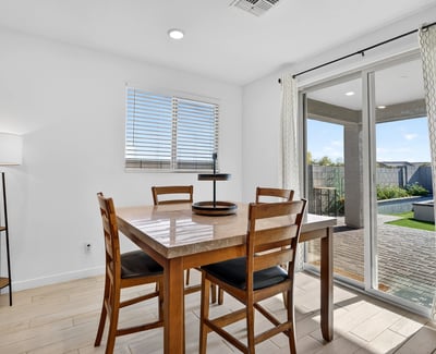 Sliding glass doors create an effortless transition from the dining area to the covered patio and professionally finished backyard, making indoor-outdoor entertaining simple and enjoyable.