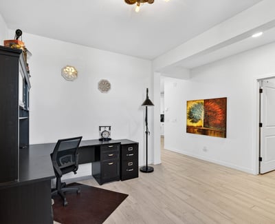 This dedicated office provides an ideal work-from-home environment with durable wood-look tile flooring, generous natural light, and versatile space for business or hobbies.