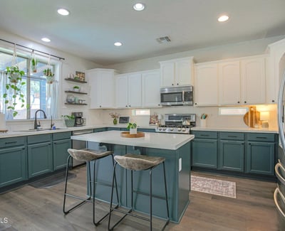 Elegant kitchen featuring quartz countertops, custom-painted cabinetry, stainless steel appliances, and a spacious island with seating. A beautifully updated centerpiece for this move-in-ready Waddell home.