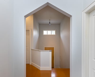 Modern entryway featuring a unique archway and spacious landing, offering a welcoming atmosphere.