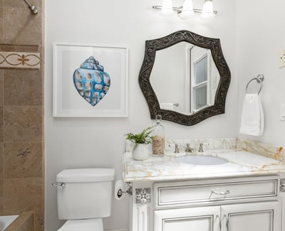 En-Suite Bathroom for Bedroom 1 
Bright bathroom featuring a decorative mirror, modern fixtures, and unique artwork, enhancing its inviting atmosphere and private direct access door to backyard
