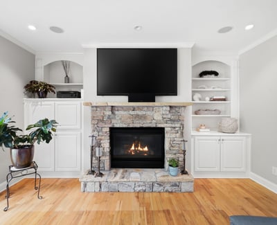 Cozy living space featuring a stone fireplace and built-in shelving, perfect for relaxation and entertainment.