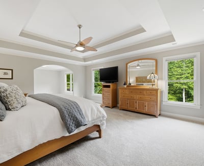 Spacious master bedroom featuring natural light, a cozy atmosphere, and modern amenities for ultimate relaxation.