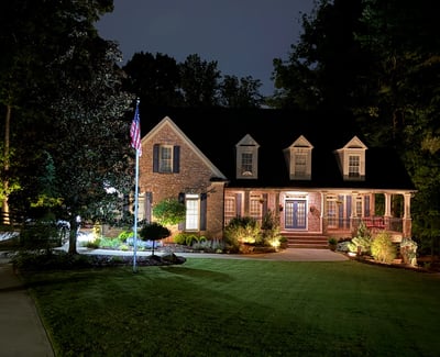 This beautifully illuminated home features inviting landscaping and ample outdoor space, perfect for evening gatherings.